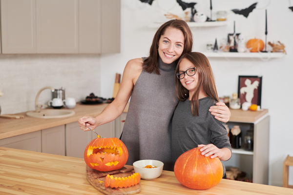 Woman and Her Daughter Prepare Pumpkins for Halloween